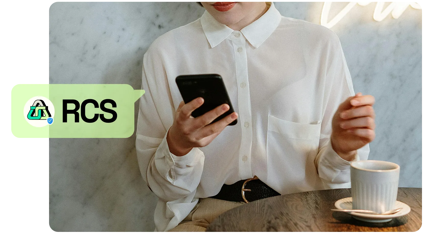 RCS image person in a cafe holding a phone